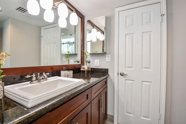 a bathroom with a sink vanity and a mirror