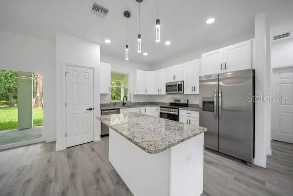 a kitchen with a refrigerator a sink and a oven