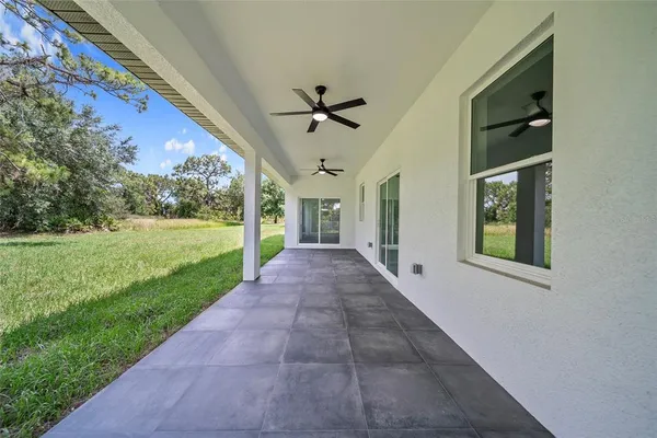 a view of a porch in front of a house with a big yard