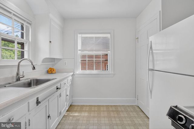 a kitchen with white cabinets and white appliances