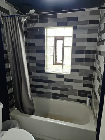 a bathroom with a bathtub and a shower