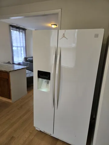 a kitchen with granite countertop a refrigerator and a sink