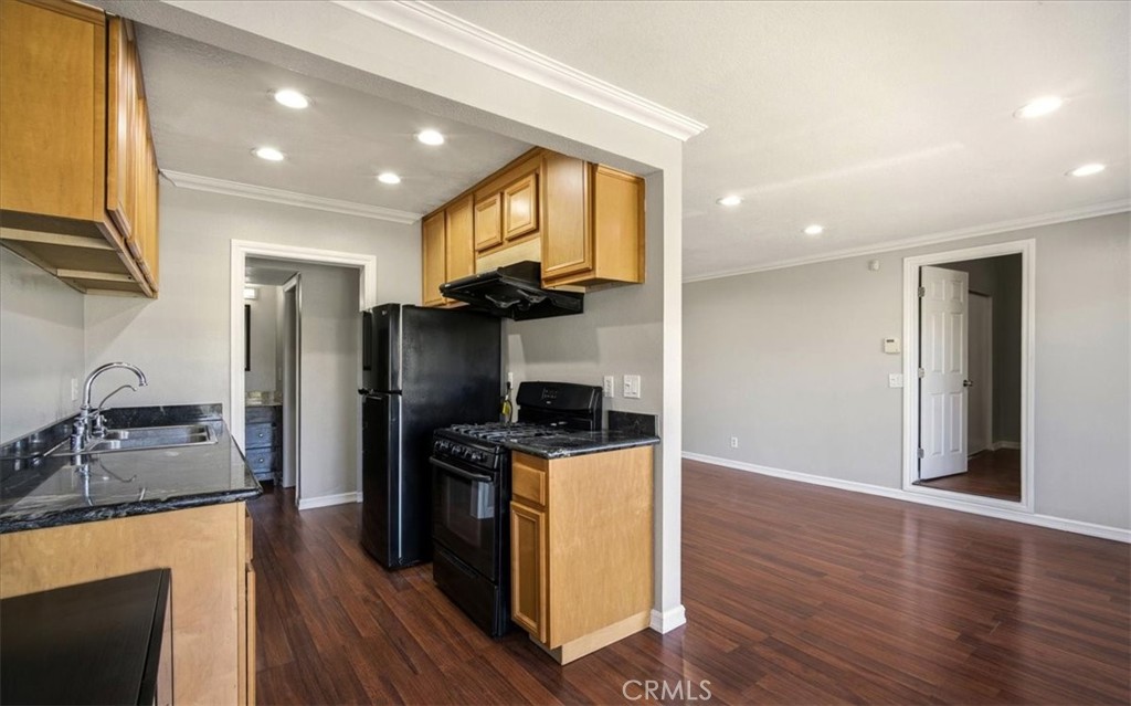 1200 West Lambert Road La Habra, CA 90631 - Photo 13 of 37 a kitchen with granite countertop a stove top oven a sink dishwasher and a refrigerator with wooden floor