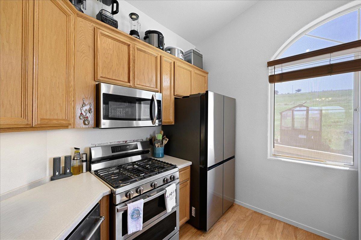 7497 McCourtney Road Lincoln, CA 95648 - Photo 16 of 73 a kitchen with stainless steel appliances granite countertop a stove a refrigerator and a microwave