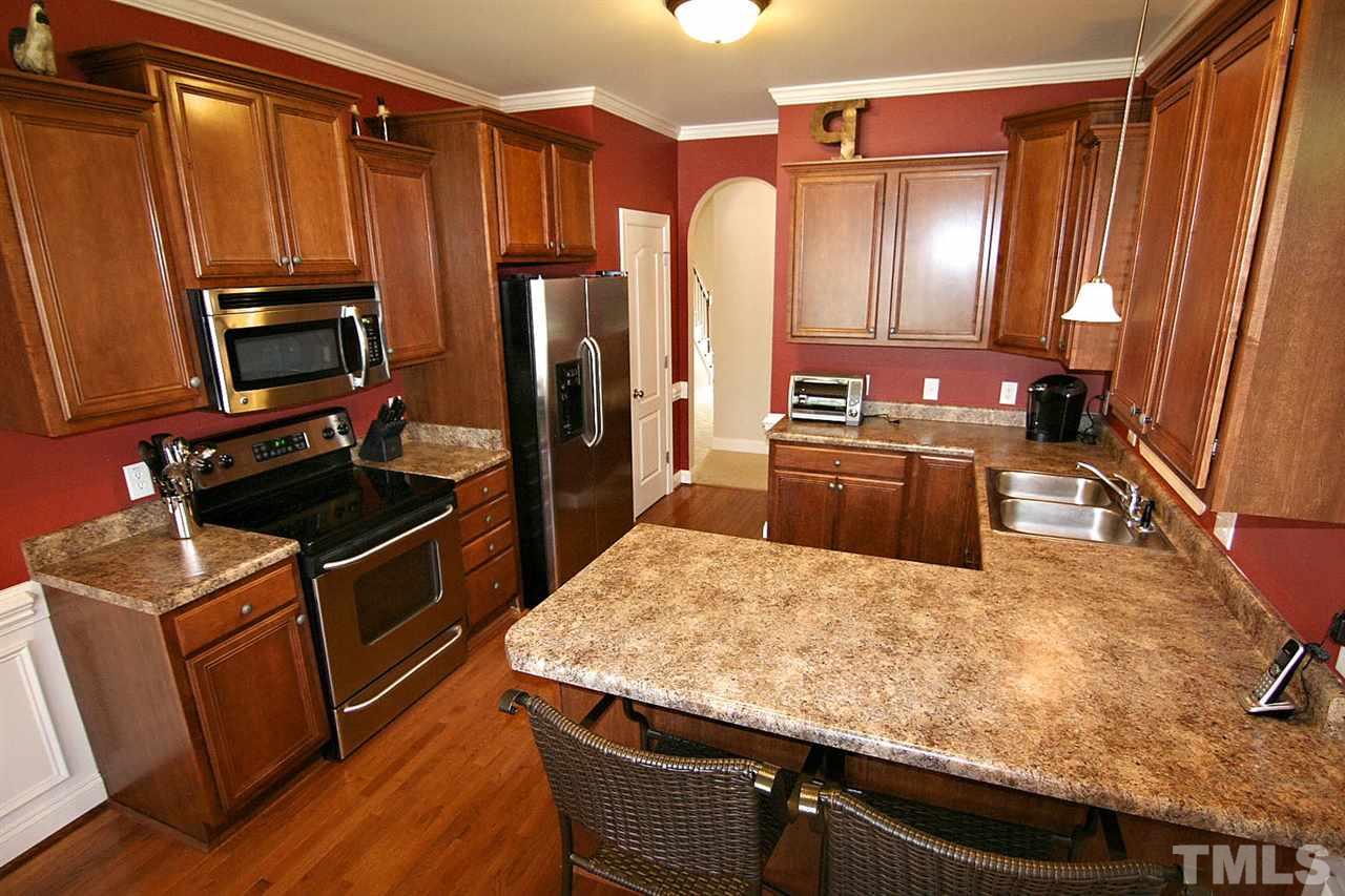 1720 Shell Cracker Drive Willow Spring, NC 27592 - Photo 4 of 10 a kitchen with kitchen island a counter top space appliances and a refrigerator
