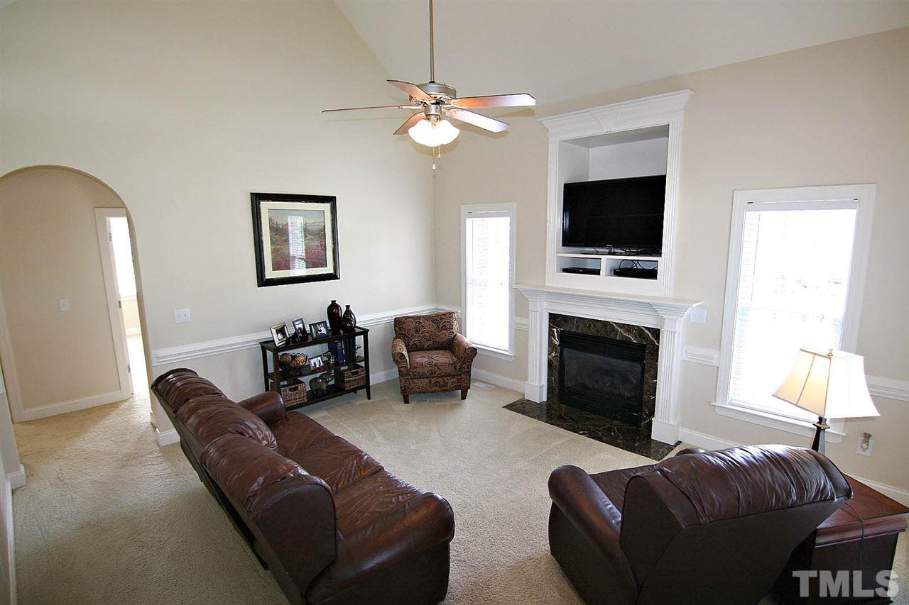 1720 Shell Cracker Drive Willow Spring, NC 27592 - Photo 10 of 10 a living room with furniture a flat screen tv and a fireplace