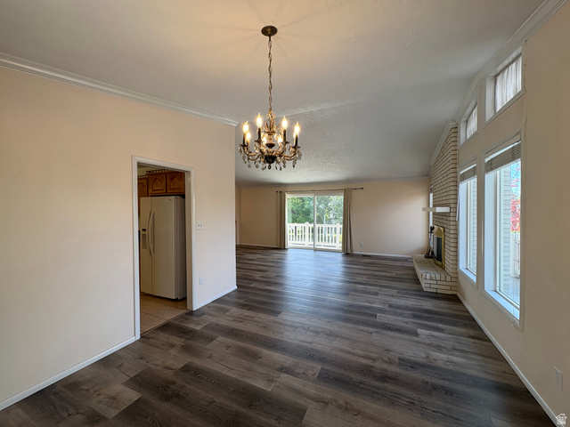 595 Meadowlark Road Orem, UT 84097 - Photo 9 of 87 Spacious living area featuring wood-finish flooring, a decorative chandelier, and a brick fireplace