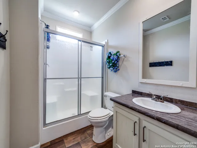 a bathroom with a granite countertop sink toilet and shower