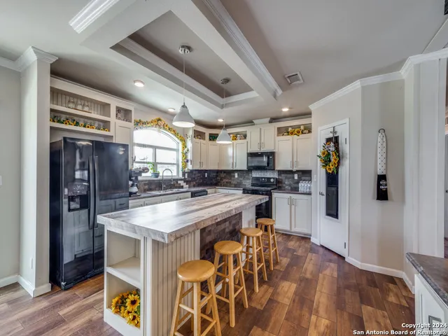 a kitchen with stainless steel appliances granite countertop a refrigerator a stove and a sink