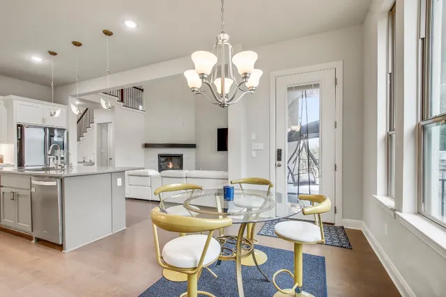 a view of a dining room with furniture a chandelier and wooden floor