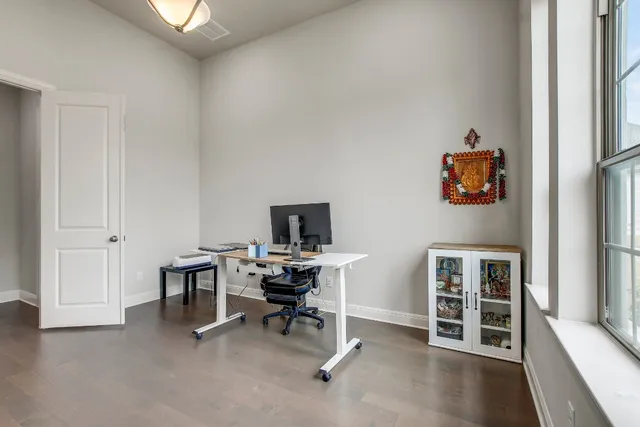 a view of a workspace with furniture and a window