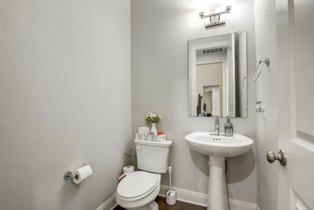 a bathroom with a sink mirror and toilet