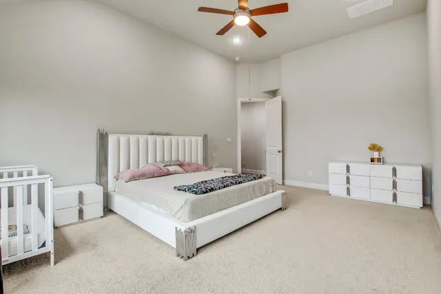 a spacious bedroom with a bed and a chandelier