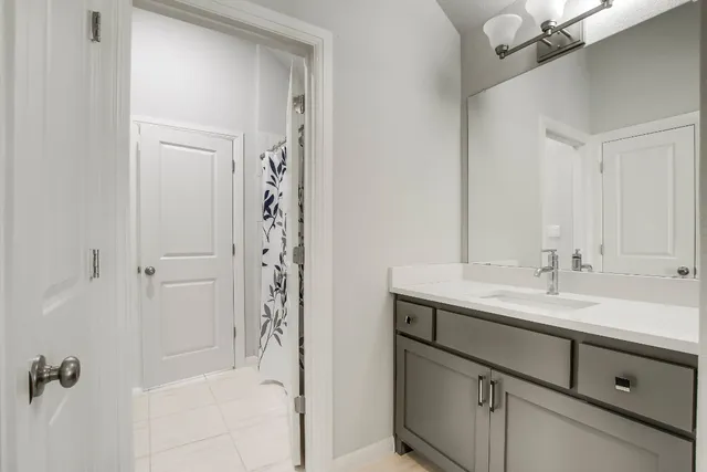 a bathroom with a granite countertop sink a mirror a vanity and a shower