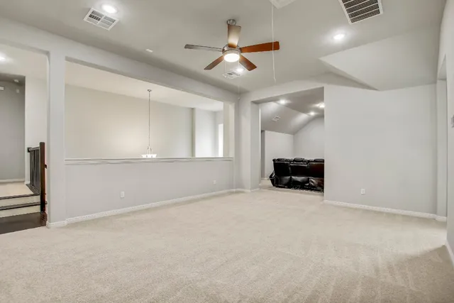 an empty room with windows and ceiling fan