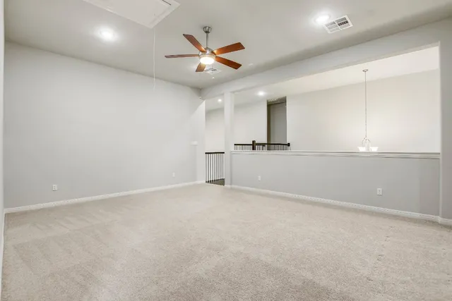 an empty room with a ceiling fan and window