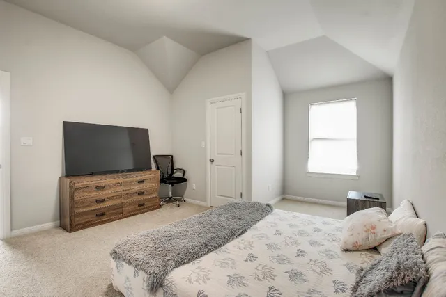 a bedroom with a bed and flat screen tv
