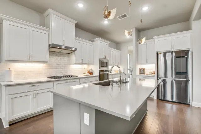 a kitchen with stainless steel appliances a sink a stove and refrigerator