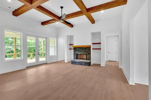 a view of empty room with fireplace and windows