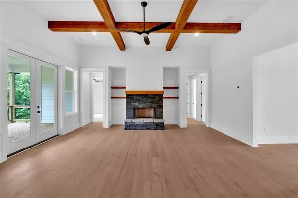 a view of an empty room with a fireplace and a window
