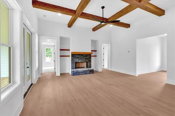 a view of empty room with fireplace and windows