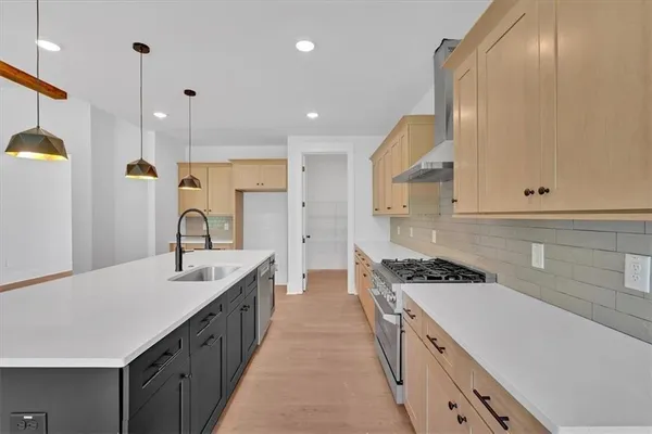 a kitchen with kitchen island a counter top space a sink stainless steel appliances and cabinets