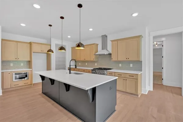 a large kitchen with stainless steel appliances kitchen island a stove a sink a center island a refrigerator and a view of living room