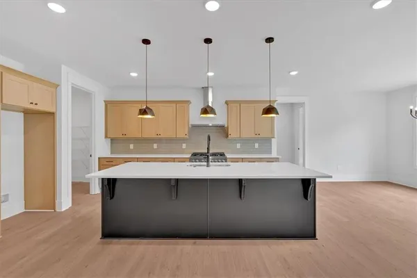 a kitchen with kitchen island a sink stainless steel appliances and cabinets