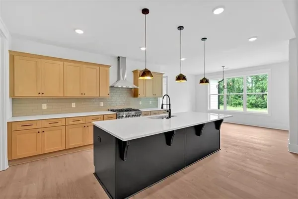 a kitchen with stainless steel appliances granite countertop a sink a stove and a wooden floors