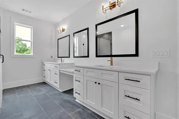 a bathroom with a double vanity sink mirror and bathtub