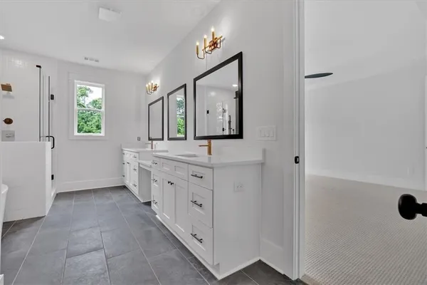 a bathroom with a double vanity sink a mirror and a bathtub