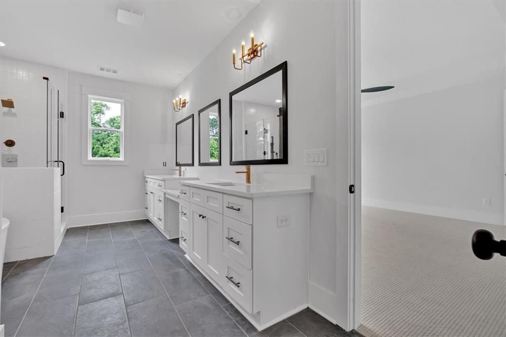 300 Eminence Peak Rydal, GA 30171 - Photo 34 of 46 a bathroom with a double vanity sink a mirror and a bathtub