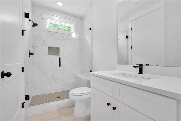 a bathroom with a sink a toilet and shower