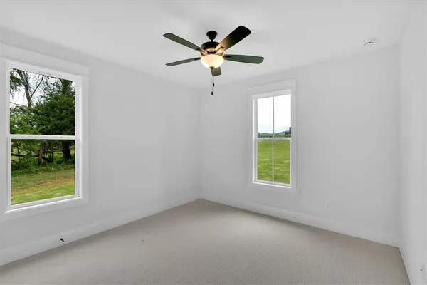 an empty room with window and ceiling fan