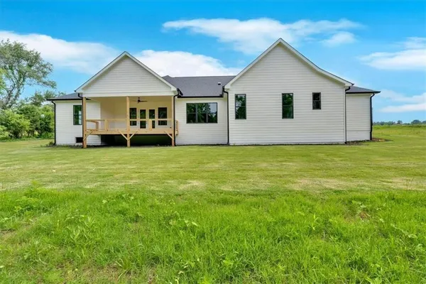 a view of a house with a big yard and sitting area