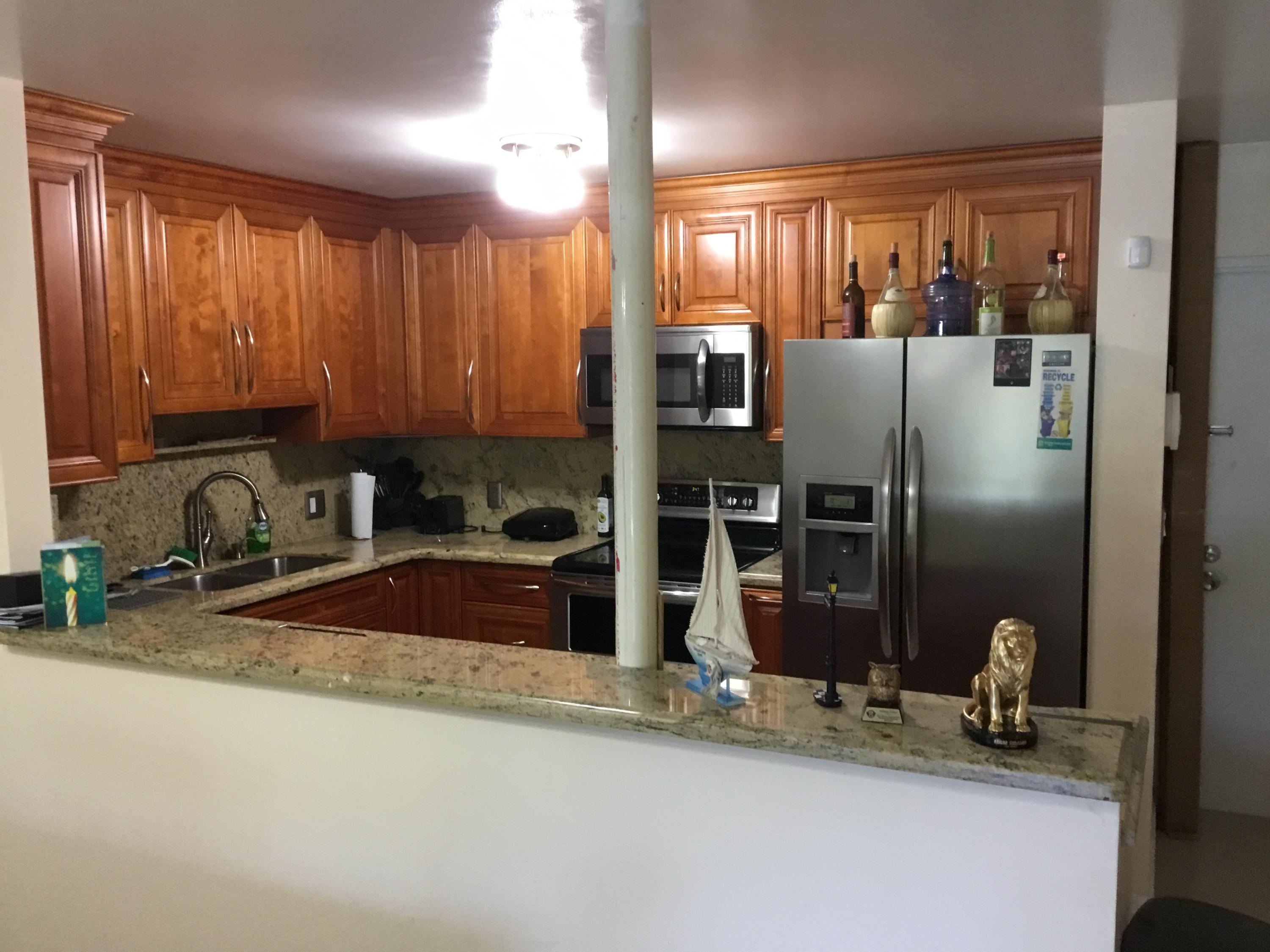 906 Southwest 9th St Circle, Unit 106 Boca Raton, FL 33486 - Photo 4 of 26 a kitchen with a refrigerator and a sink