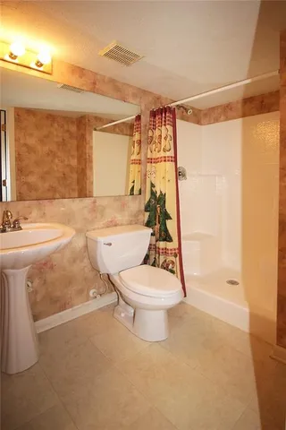 a bathroom with a toilet a sink and shower
