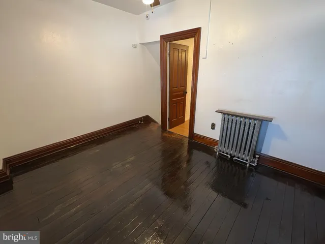 an empty room with wooden floor and bench