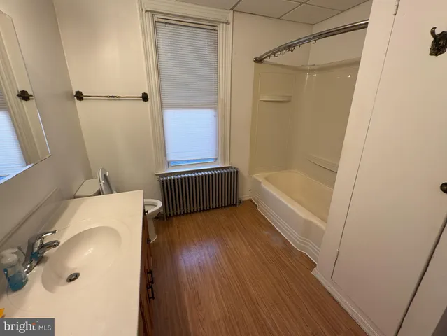a bathroom with a tub shower and vanity