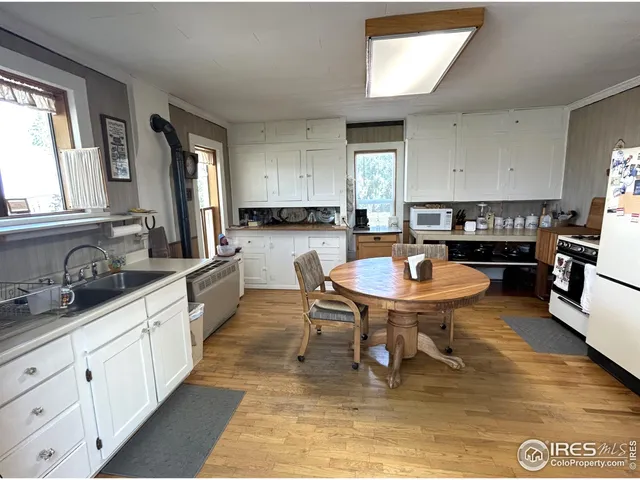 a kitchen with a dining table chairs and sink