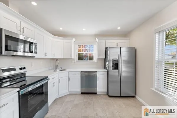 a kitchen with stainless steel appliances granite countertop a refrigerator a sink a stove a microwave and island