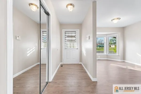 a view of a hallway with wooden floor and windows