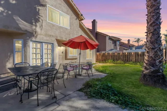 a view of a house with backyard and sitting area