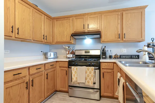a kitchen with stainless steel appliances granite countertop a stove and white cabinets