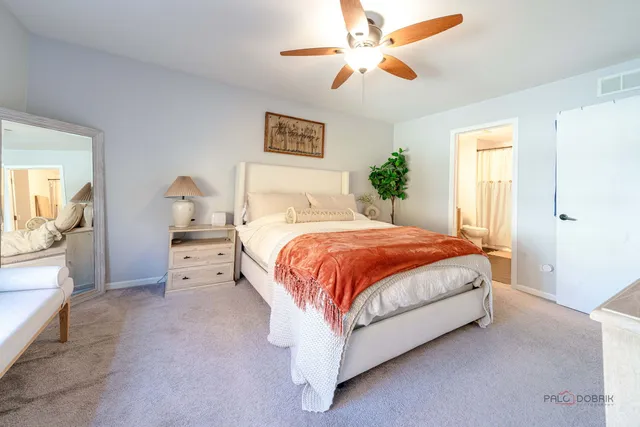 a spacious bedroom with a bed and a chandelier