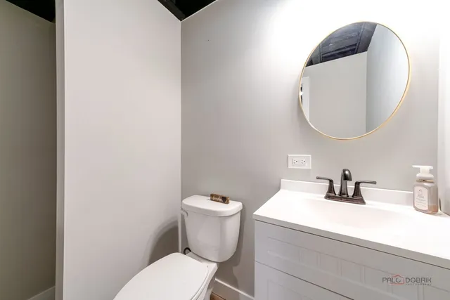 a bathroom with a toilet sink and mirror