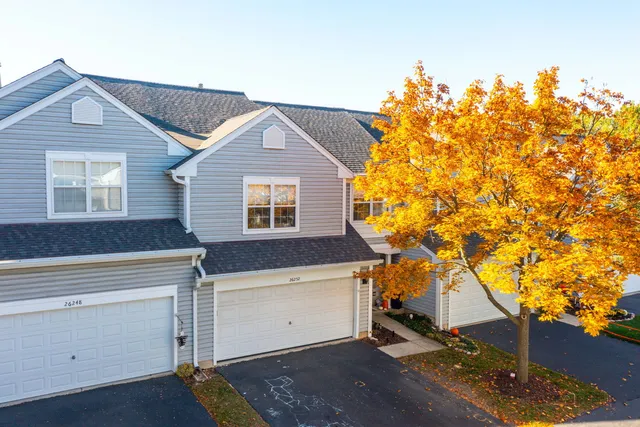 a front view of a house with a tree