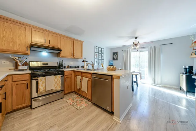 a kitchen with granite countertop a stove top oven a sink a counter space and cabinets