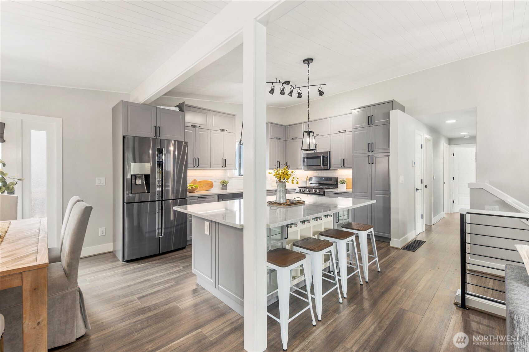 9 216th Street Southeast Bothell, WA 98021 - Photo 5 of 28 a kitchen with stainless steel appliances kitchen island granite countertop a refrigerator a stove a microwave oven a dining table and chairs with wooden floor