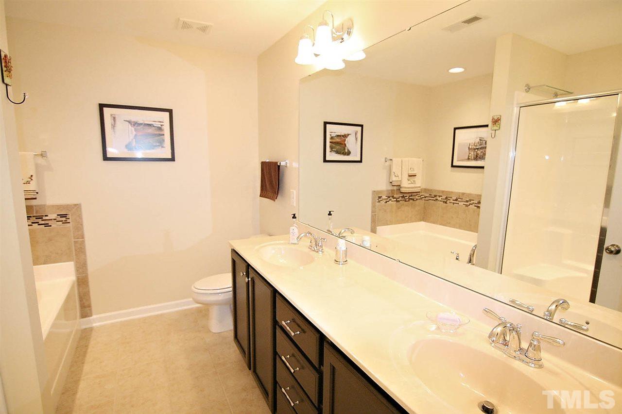 2433 Memory Ridge Drive Raleigh, NC 27606 - Photo 14 of 24 a bathroom with a sink a toilet a mirror and shower